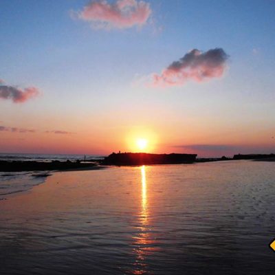 In Canggu geht die Sonne über dem Meer unter und hüllt Strand und Meer in ein faszinierendes Farbspektrum