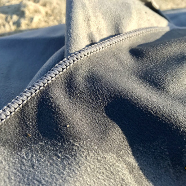 Auch in Sachen Schmutzempfindlichkeit schneidet das Fit Flip Badetuch in unserem Mikrofaser Handtuch Test gut ab. Die Erdkörner liegen nur auf der Oberfläche auf, aber setzen sich nicht im Handtuch fest.