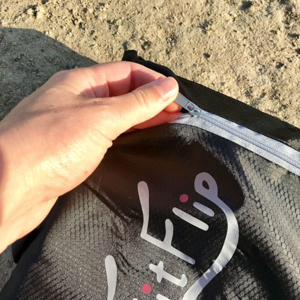 Die Transporttasche des großen Mikrofaser Reisehandtuchs von Fit Flip lässt sich mit einem Reißverschluss öffnen und schließen